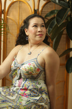 Woman wearing a colorful patterned dress with a wooden background
