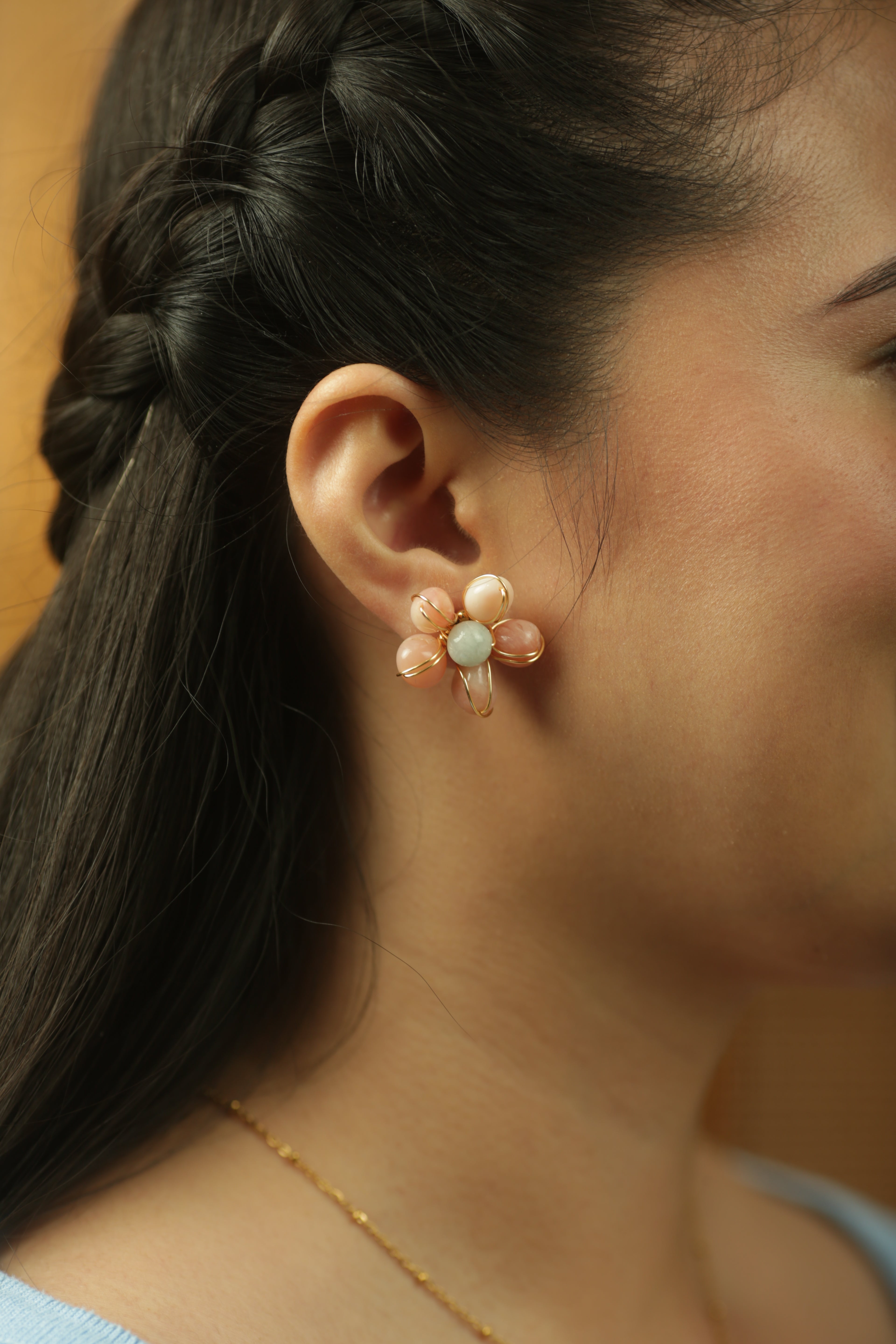 Close-up of a woman wearing a floral earring with a blurred background