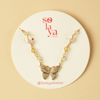 Butterfly necklace on a white card with 'solaya' branding on a beige background