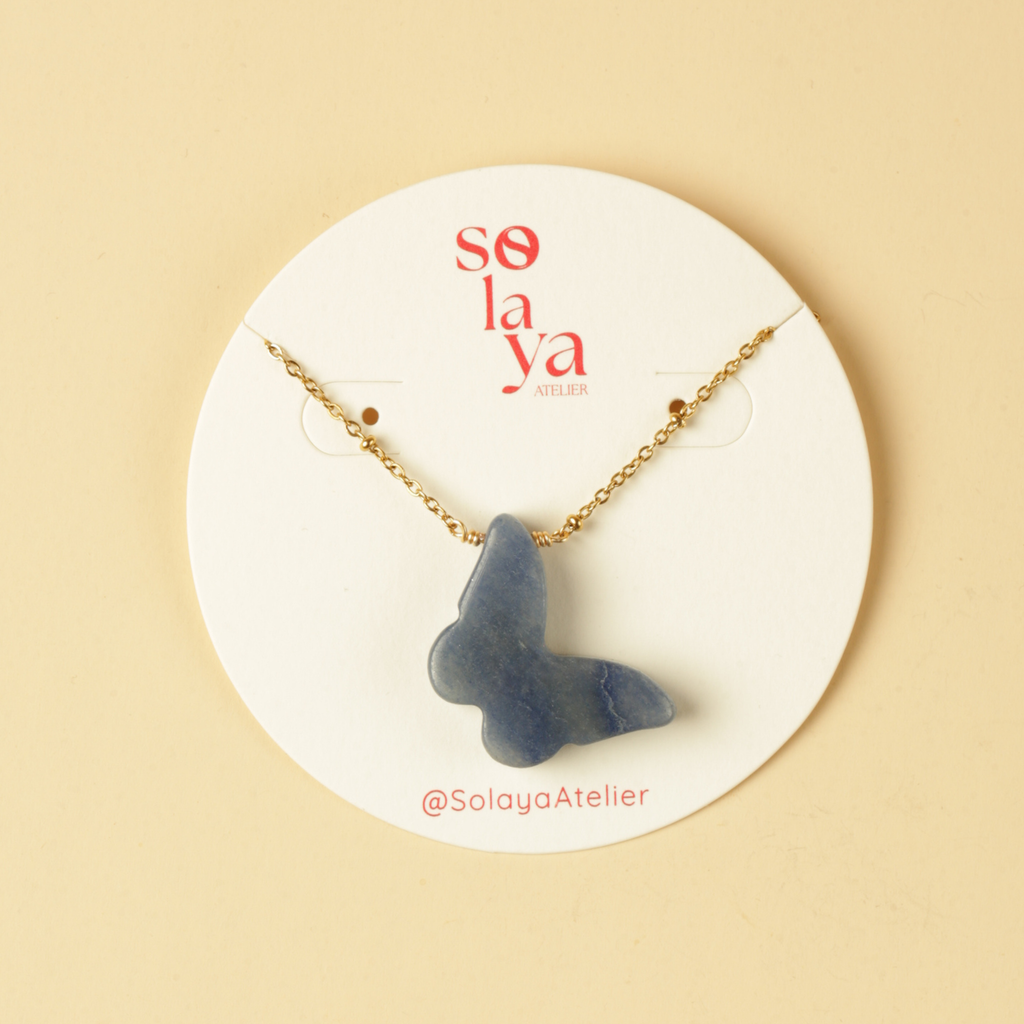 Necklace with a blue pendant on a Solaya Atelier branded card against a beige background