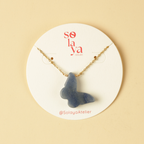 Necklace with a blue pendant on a Solaya Atelier branded card against a beige background
